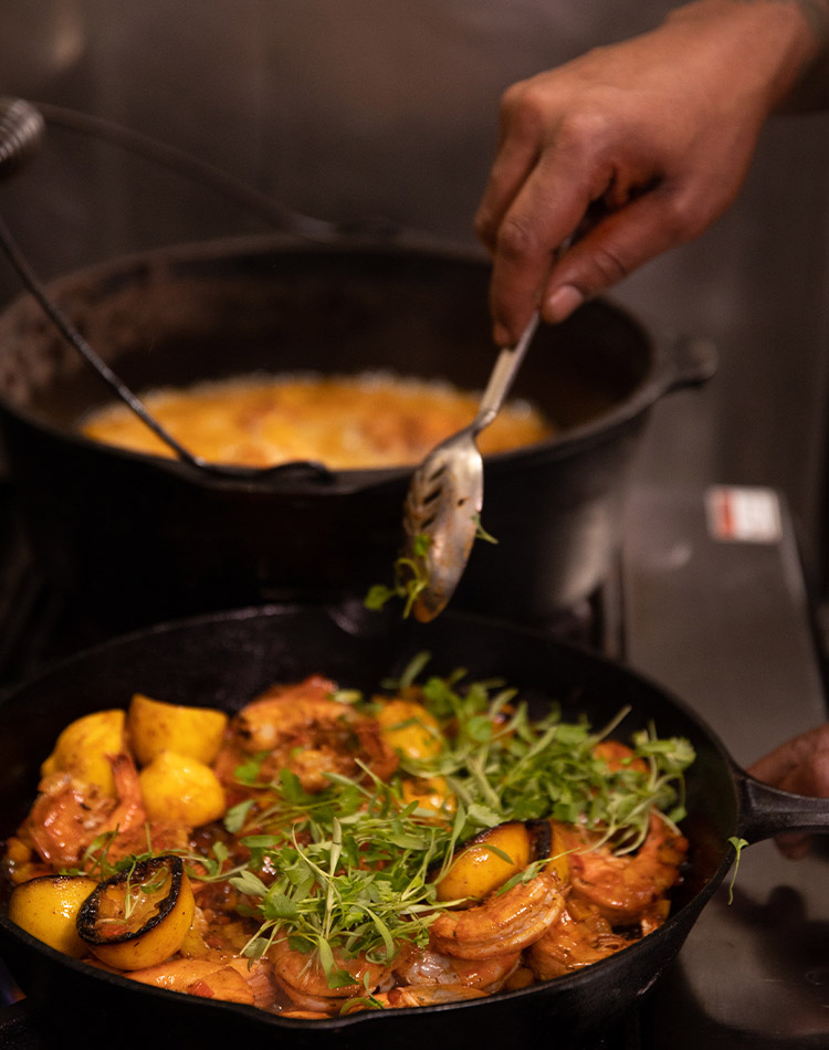 Shrimp and lemons are prepared in a cast iron skillet with taragon.